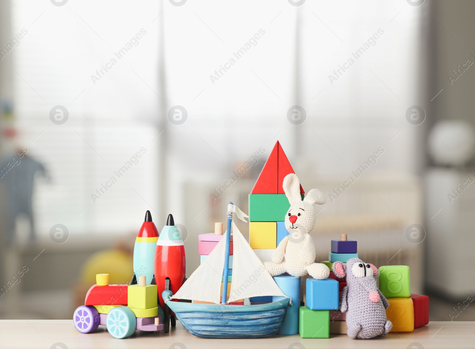 Image of Set of different cute toys on wooden table in children's room