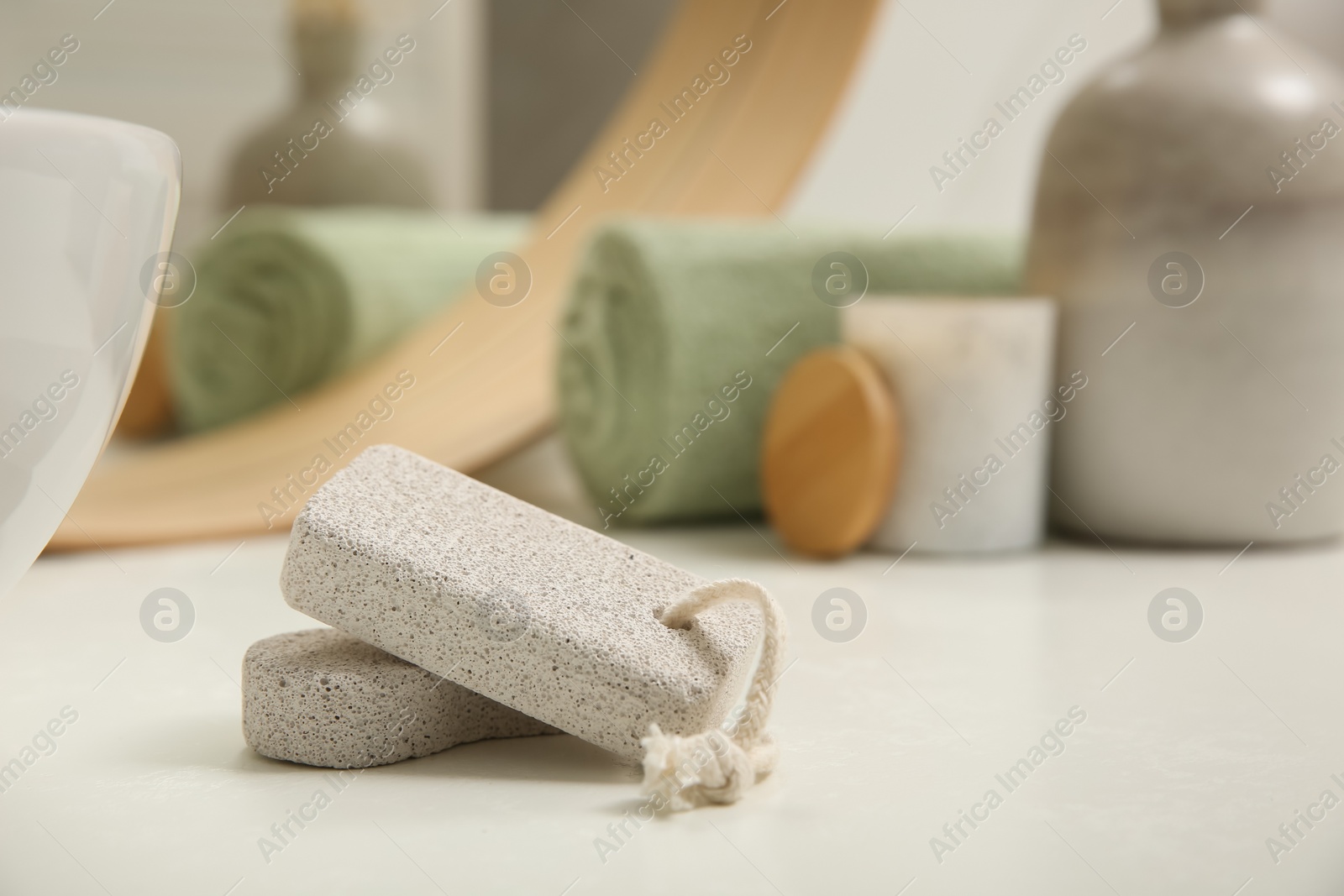 Photo of Pumice stones on white table in bathroom, space for text