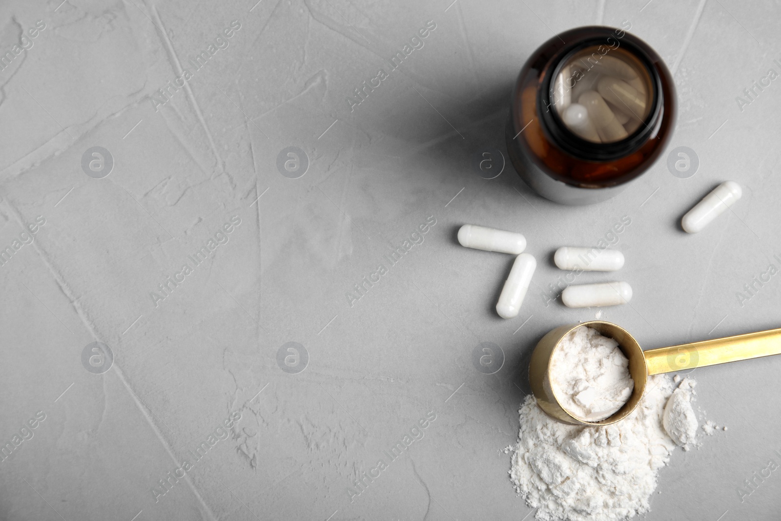 Photo of Amino acid pills and powder on grey table, flat lay. Space for text