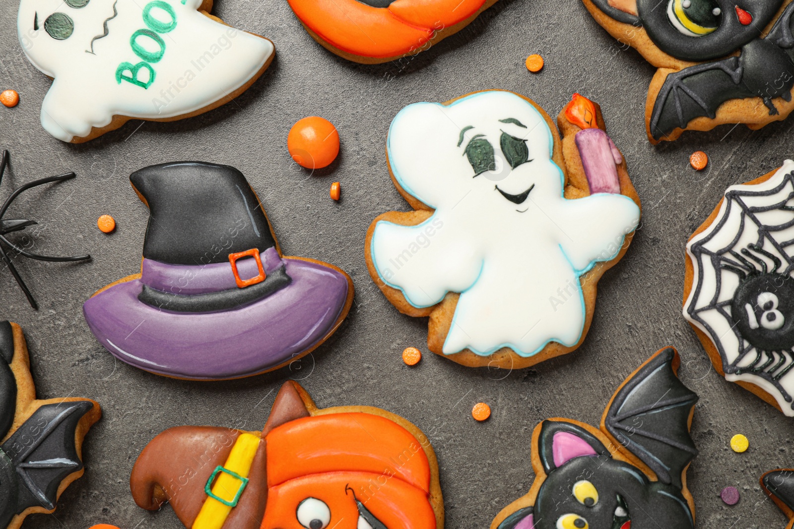 Photo of Tasty cookies and sweets for Halloween party on black table, flat lay