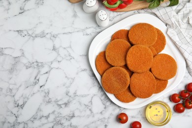 Photo of Delicious fried breaded cutlets, spices and vegetables on white marble table, flat lay. Space for text