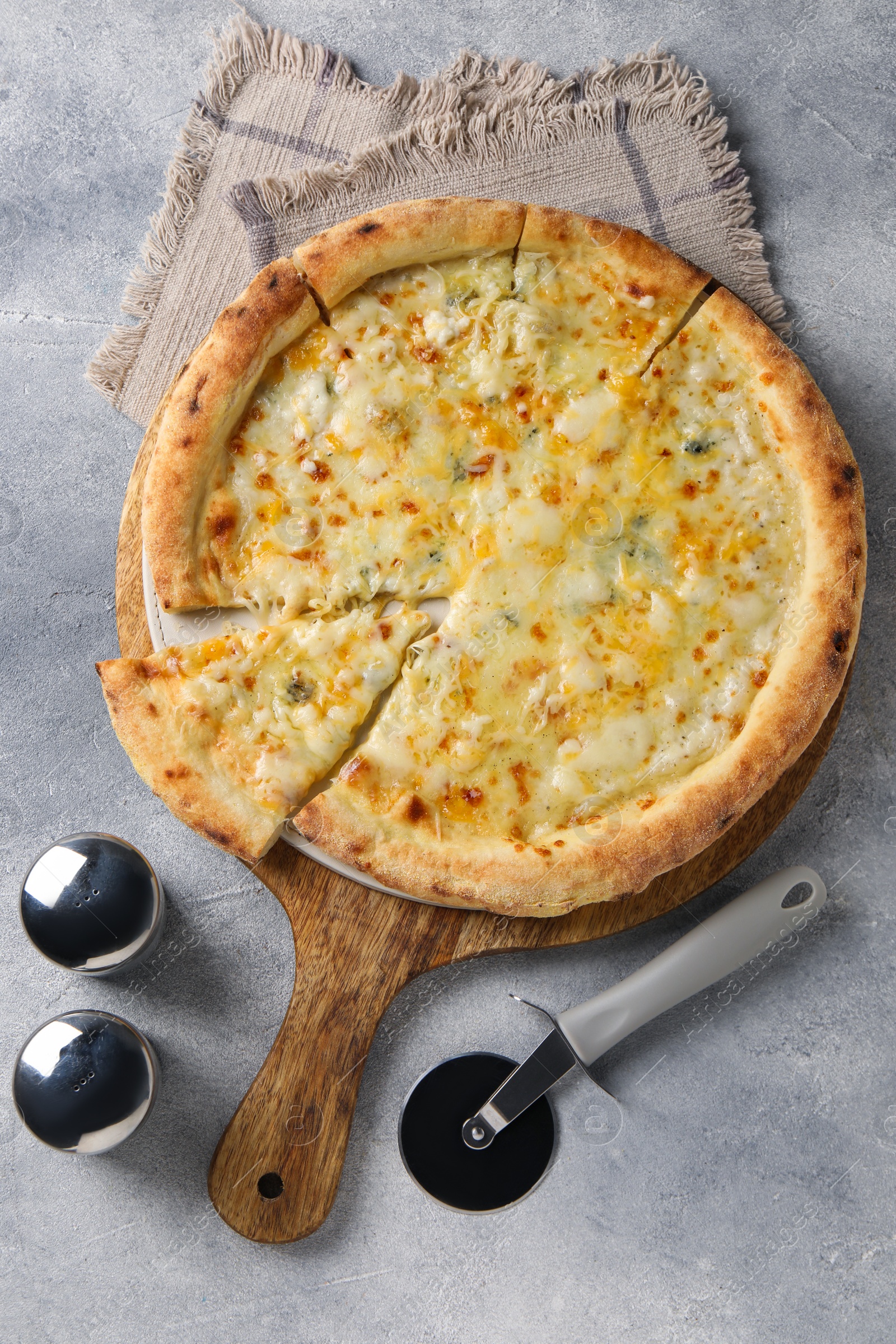 Photo of Delicious cheese pizza and cutter on light grey table, flat lay