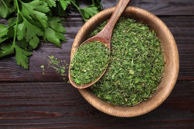 Dried aromatic parsley and fresh leaves on wooden table, flat lay. Space for text