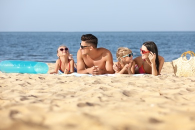 Happy family on sandy beach near sea. Summer holidays