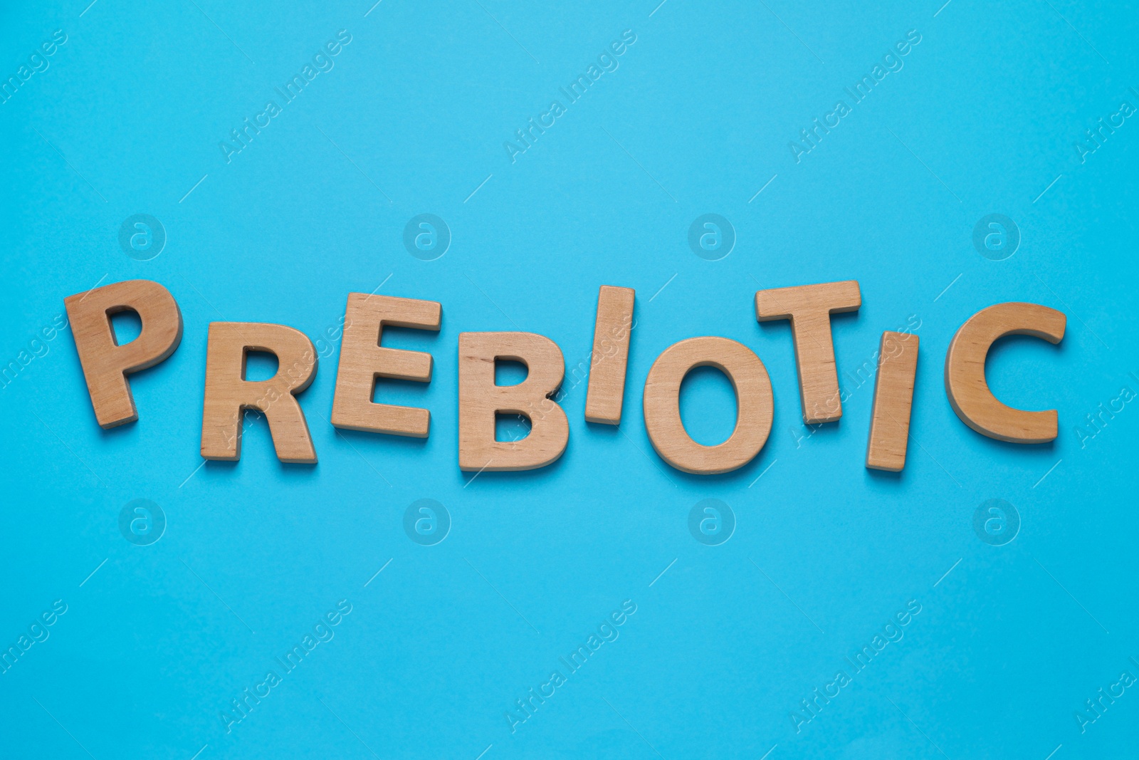 Photo of Word Prebiotic made of wooden letters on light blue background, flat lay