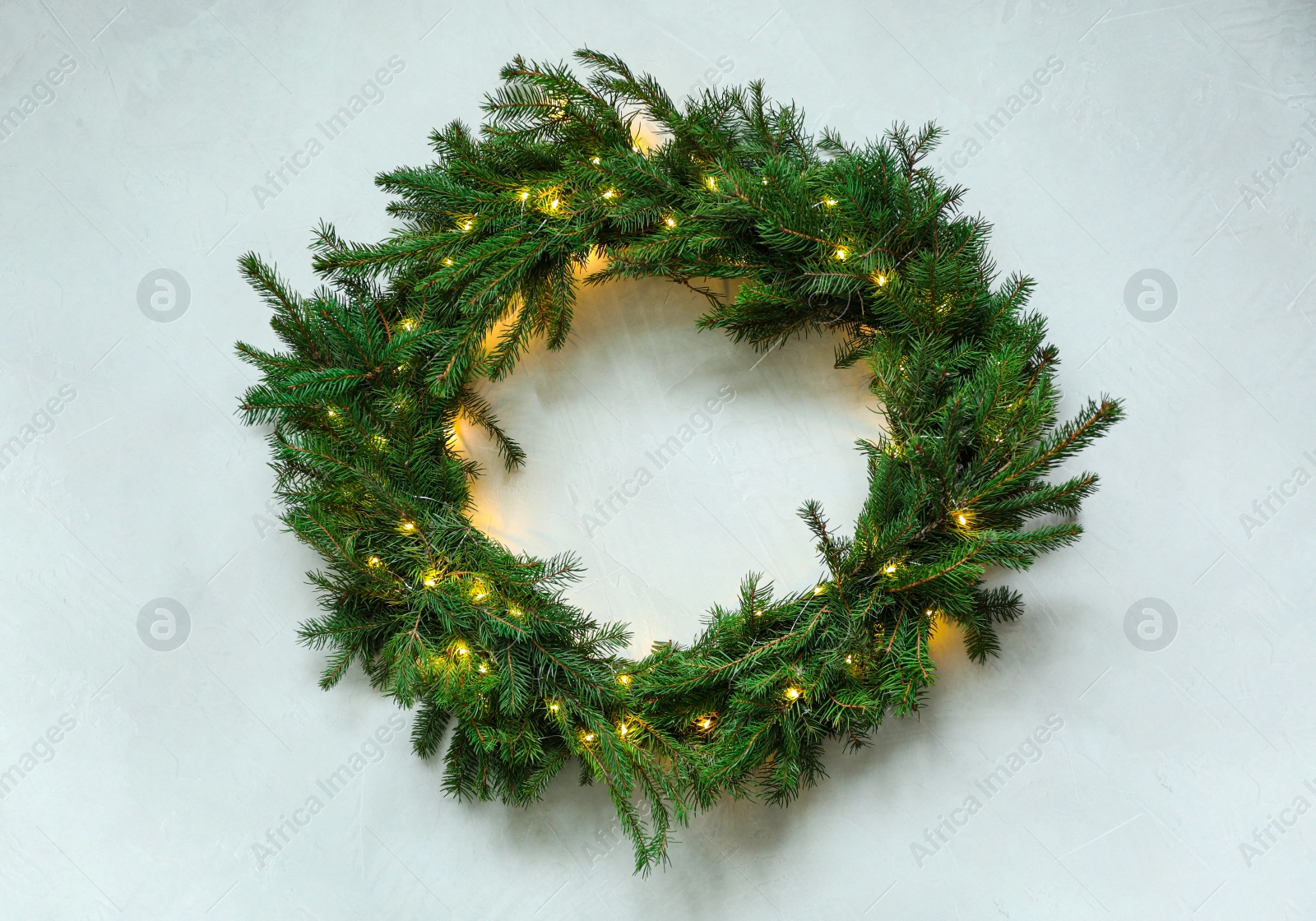 Photo of Beautiful Christmas wreath with festive lights on white background, top view