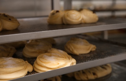 Photo of Rack with different unbaked pastries in workshop