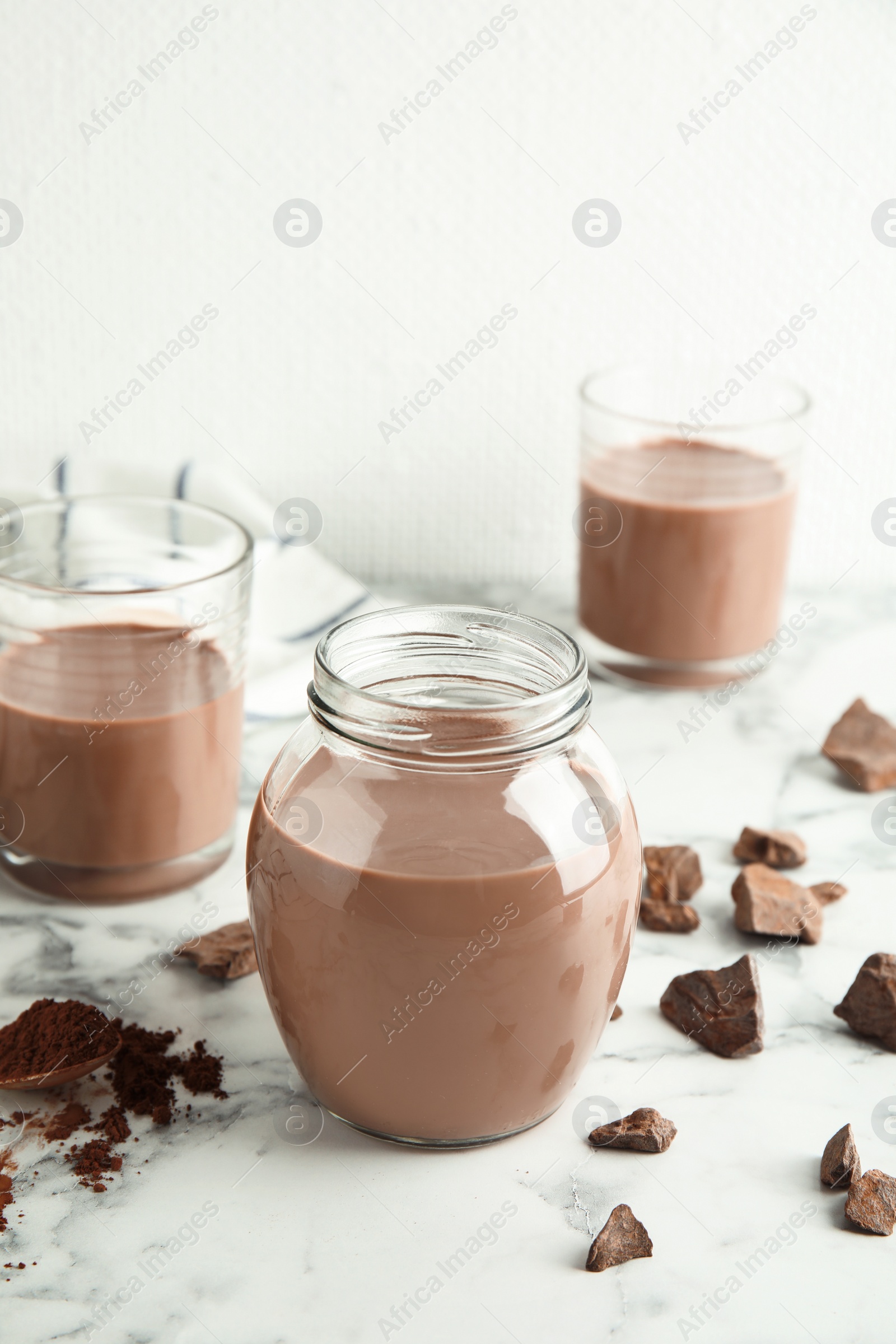 Photo of Glassware with tasty chocolate milk on marble table. Dairy drink