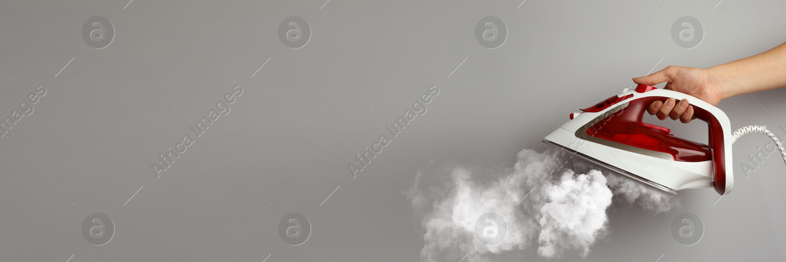 Image of Woman with iron on light grey background, closeup. Banner design with space for text