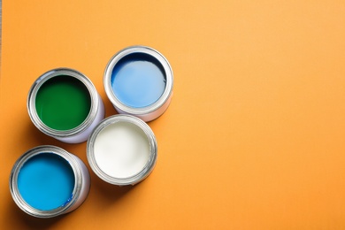 Photo of Flat lay composition with paint cans and space for text on color background