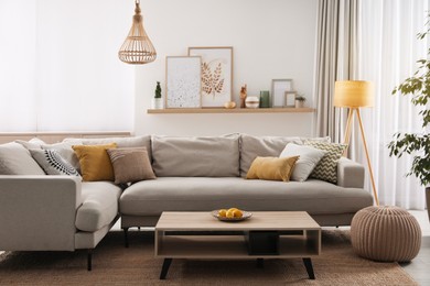 Stylish living room interior with comfortable grey sofa and coffee table