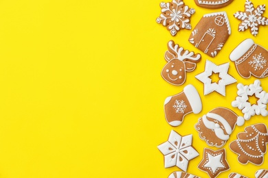 Photo of Different Christmas gingerbread cookies on yellow background, flat lay. Space for text