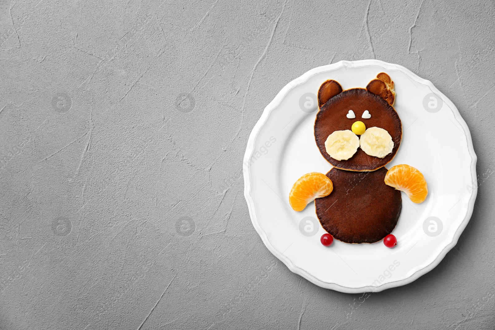 Photo of Plate with chocolate pancakes in form of cat on grey background. Creative breakfast ideas for kids