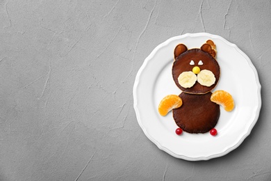 Plate with chocolate pancakes in form of cat on grey background. Creative breakfast ideas for kids