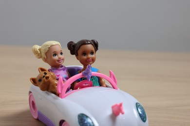 Photo of Leiden, Netherlands - September 20, 2023: Beautiful Chelsea dolls with pet in toy car on table against light gray background, space for text