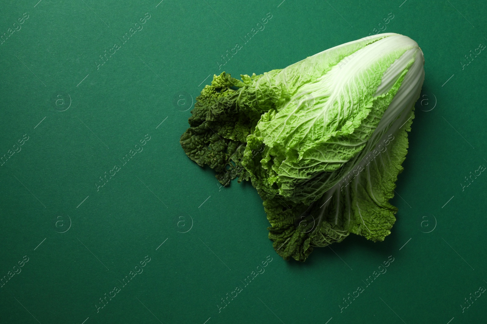 Photo of Fresh ripe Chinese cabbage on green background, top view. Space for text