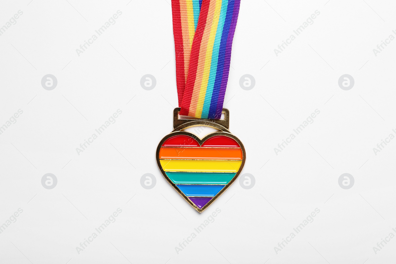 Photo of Rainbow ribbon with heart pendant on white background, top view. LGBT pride