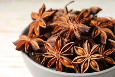 Many aromatic anise stars in bowl, closeup