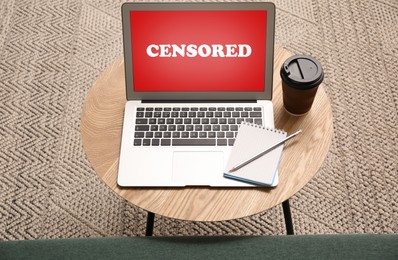 Laptop with censorship sign on wooden table indoors