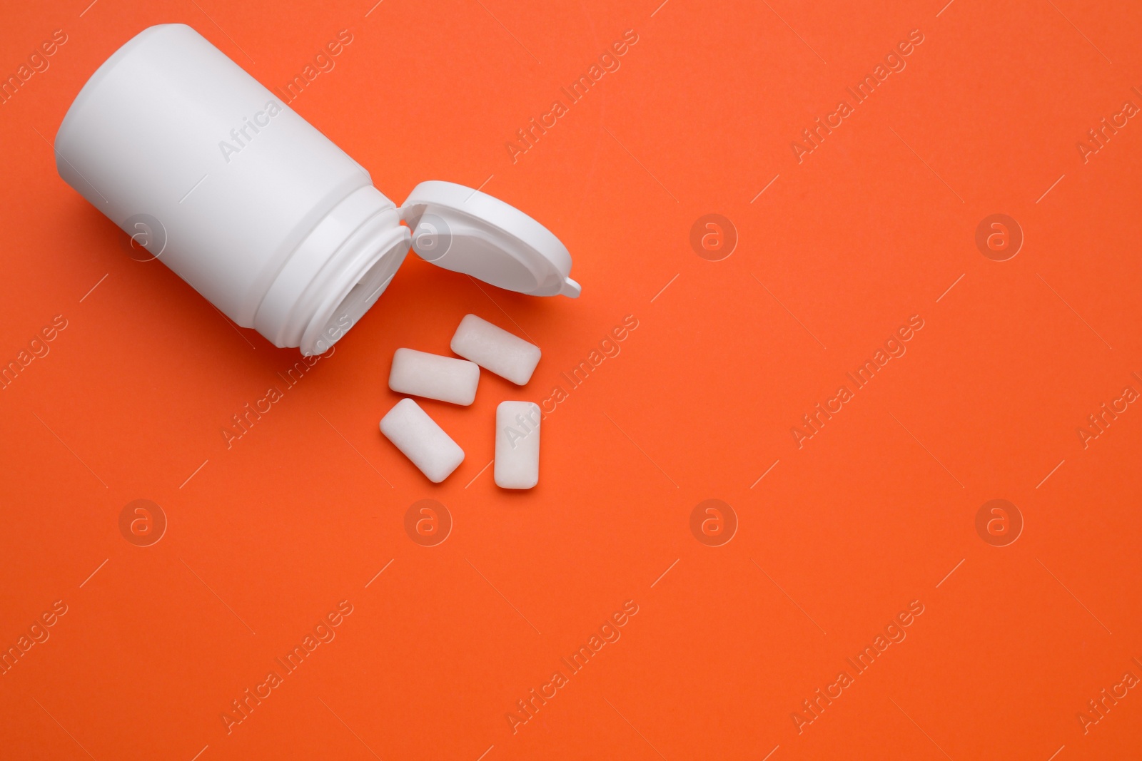 Photo of Jar with chewing gums on orange background, flat lay. Space for text