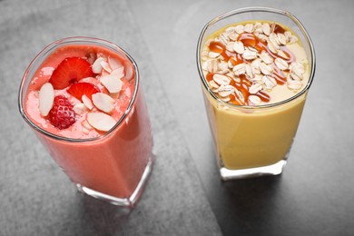 Photo of Different delicious smoothies on grey table, above view