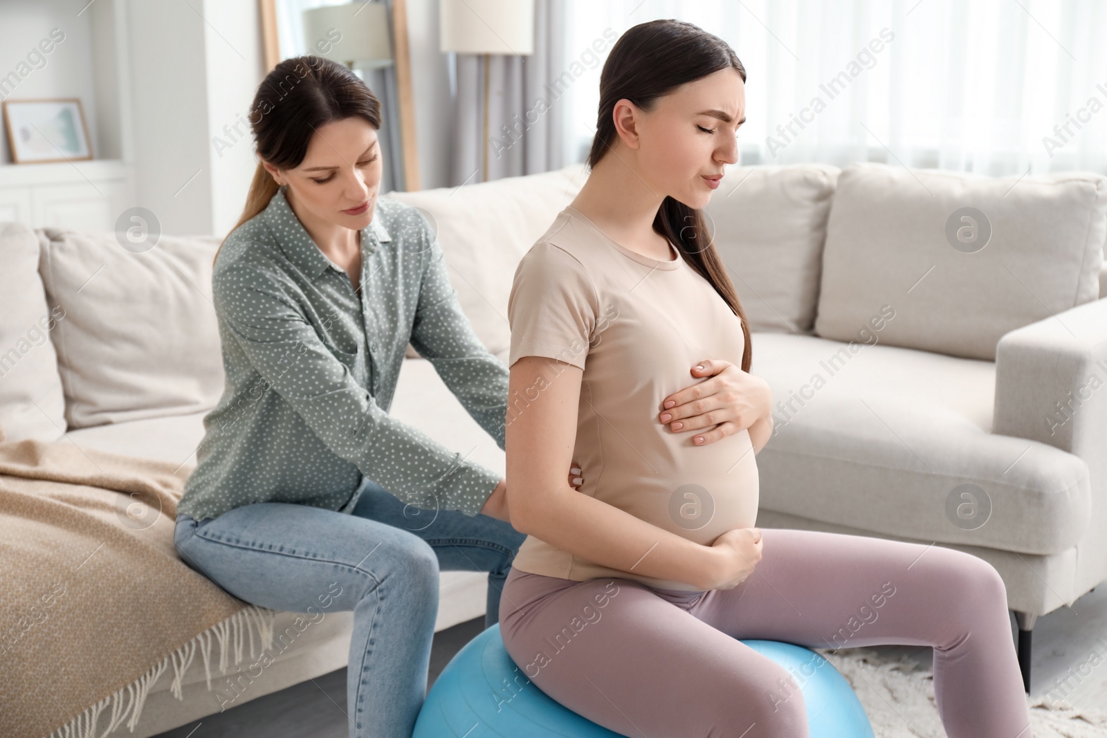 Photo of Doula working with pregnant woman at home. Preparation for child birth