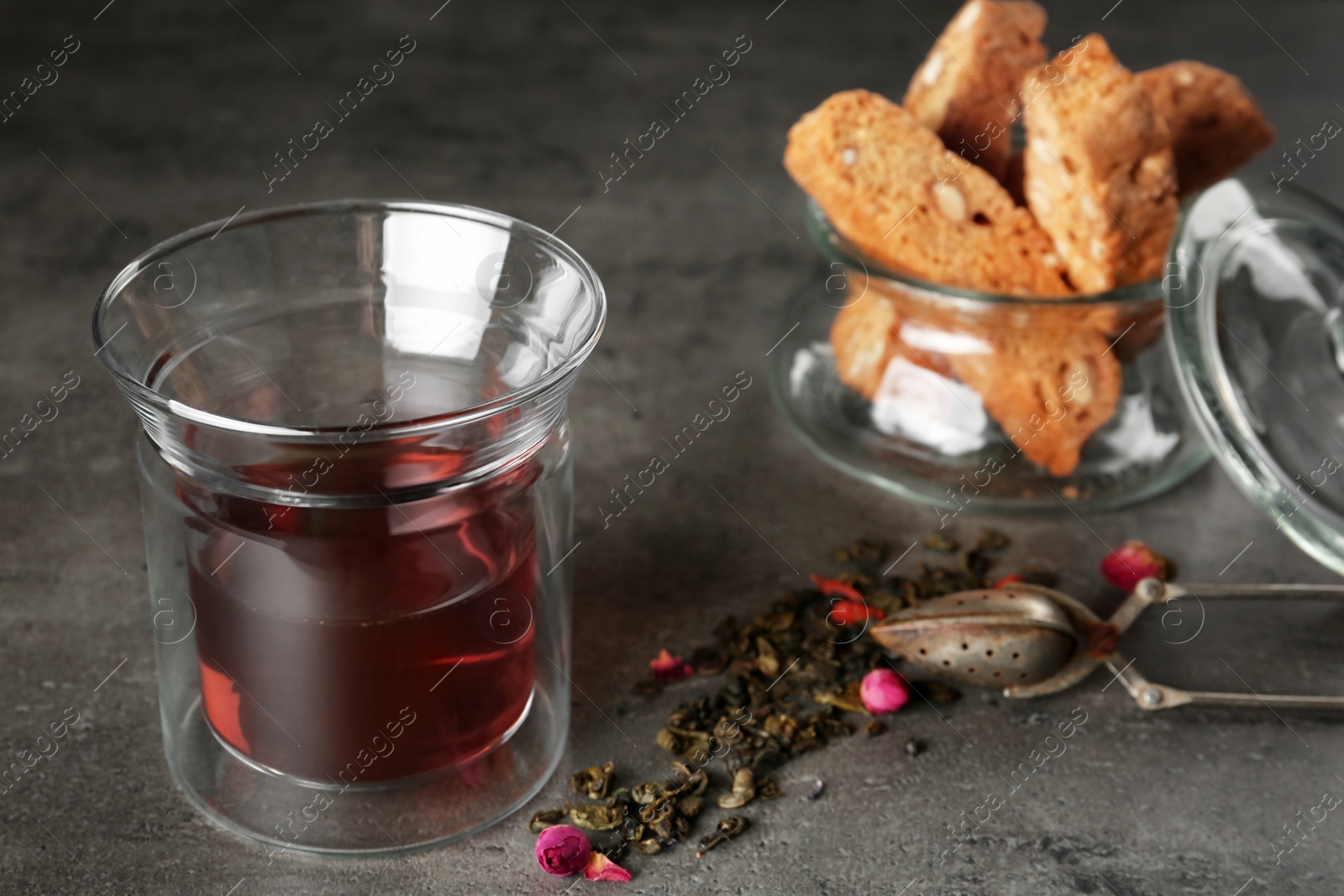 Photo of Composition with glass of hot aromatic tea on grey table