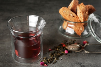 Composition with glass of hot aromatic tea on grey table