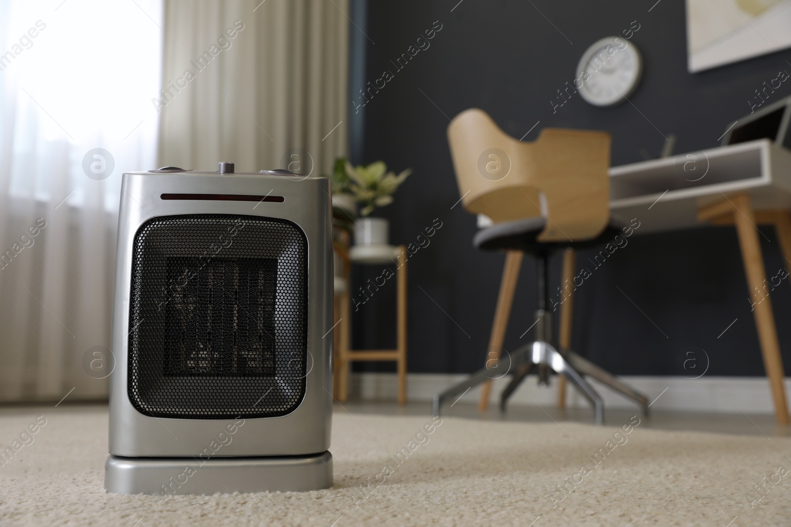Photo of Modern electric infrared heater on floor in room interior, closeup. space for text