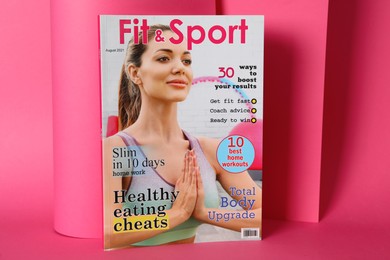 Photo of Modern printed sports magazine on pink background