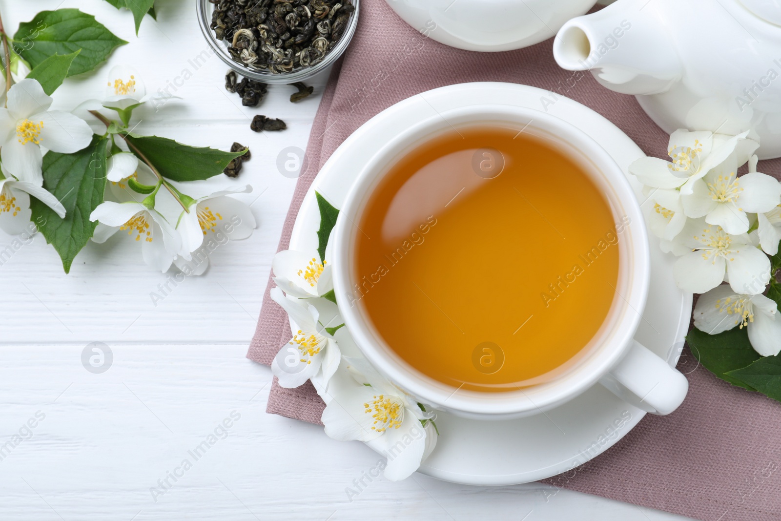 Photo of Flat lay composition with tea and fresh jasmine flowers on white wooden table