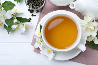 Photo of Flat lay composition with tea and fresh jasmine flowers on white wooden table