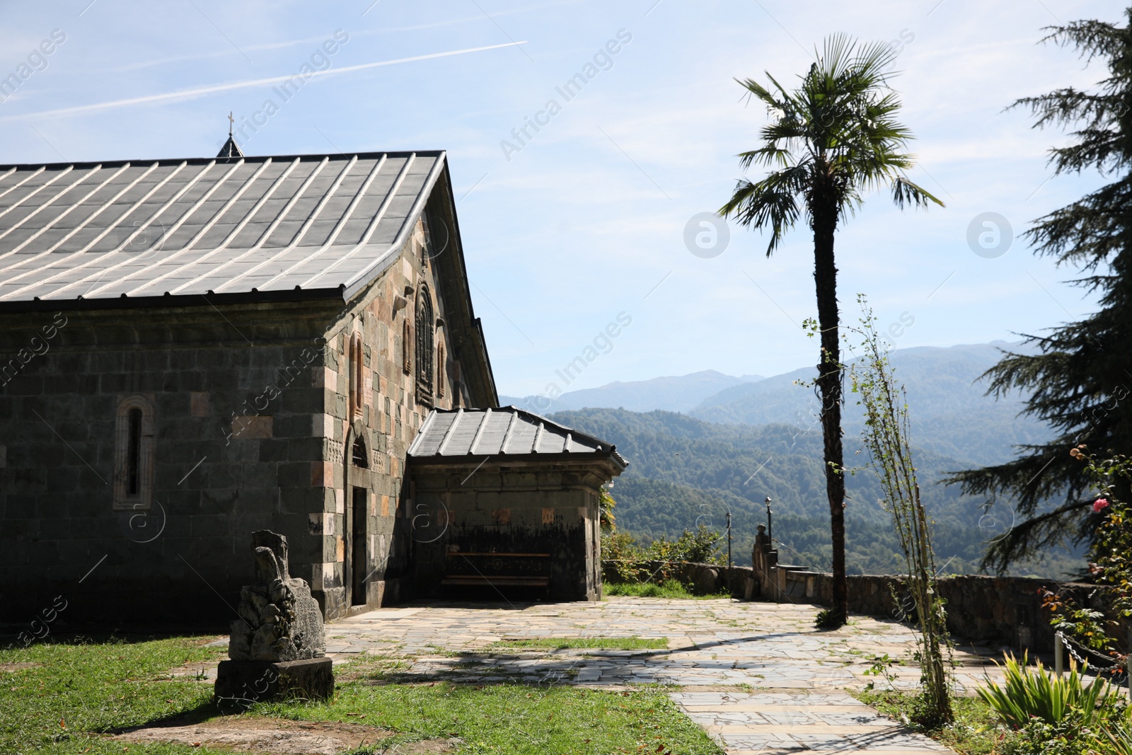 Photo of Beautiful view of church, palm tree and mountains on sunny day