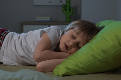 Little boy snoring while sleeping on bed at night