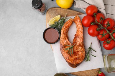 Photo of Fresh marinade, cooked fish and other products on grey table, flat lay. Space for text