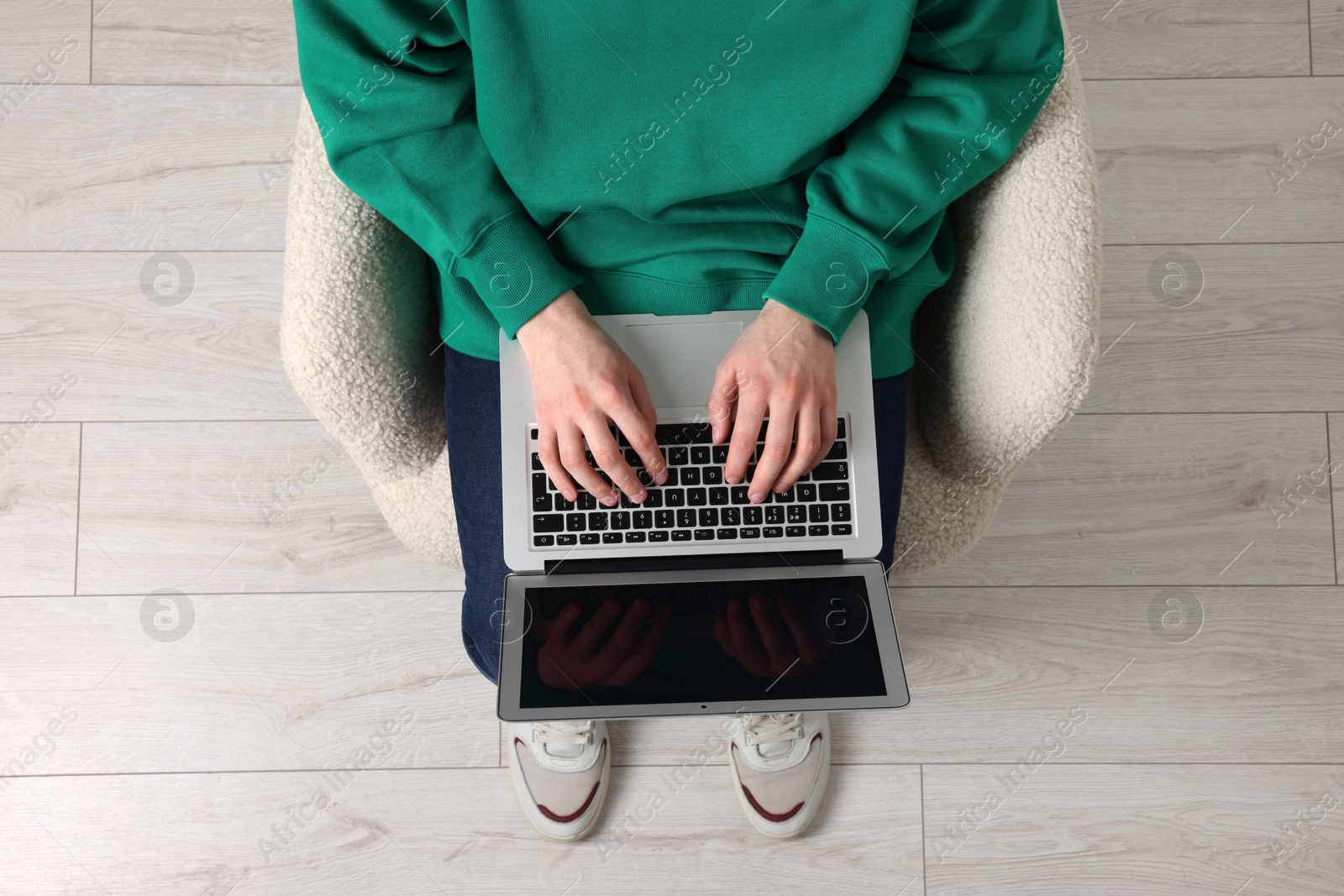 Photo of Man working with laptop in armchair, top view