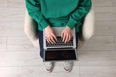 Man working with laptop in armchair, top view