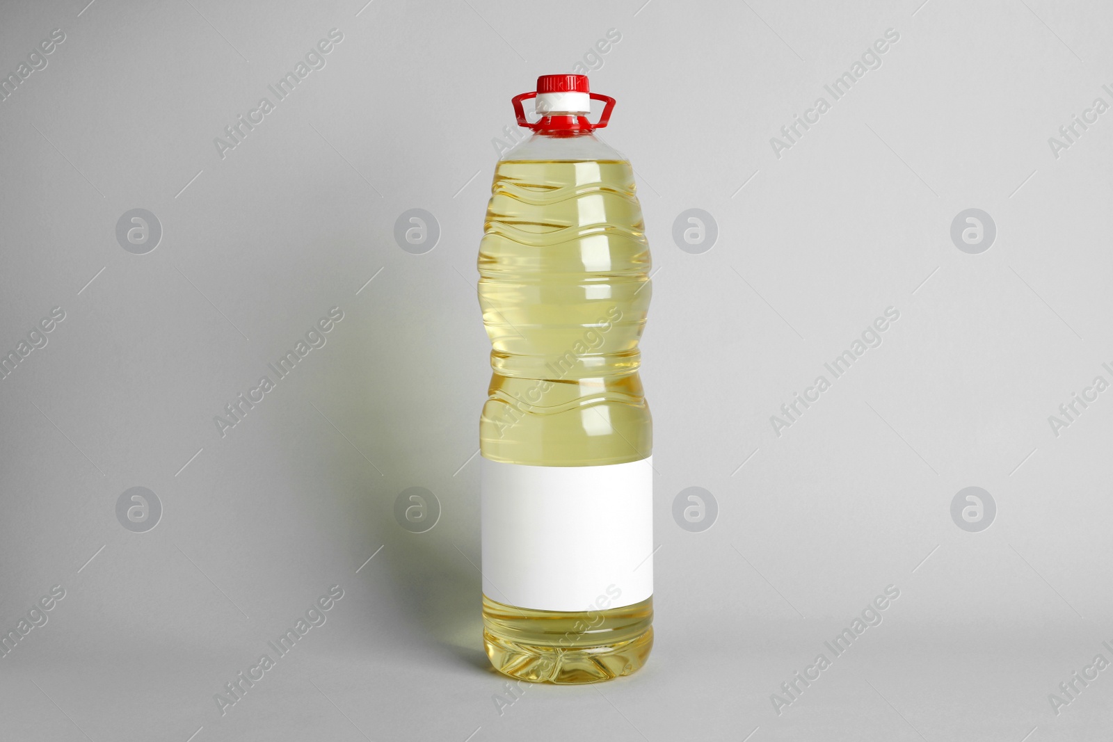 Photo of Bottle of cooking oil on light grey background