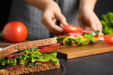 Tasty sandwich on black table, closeup view