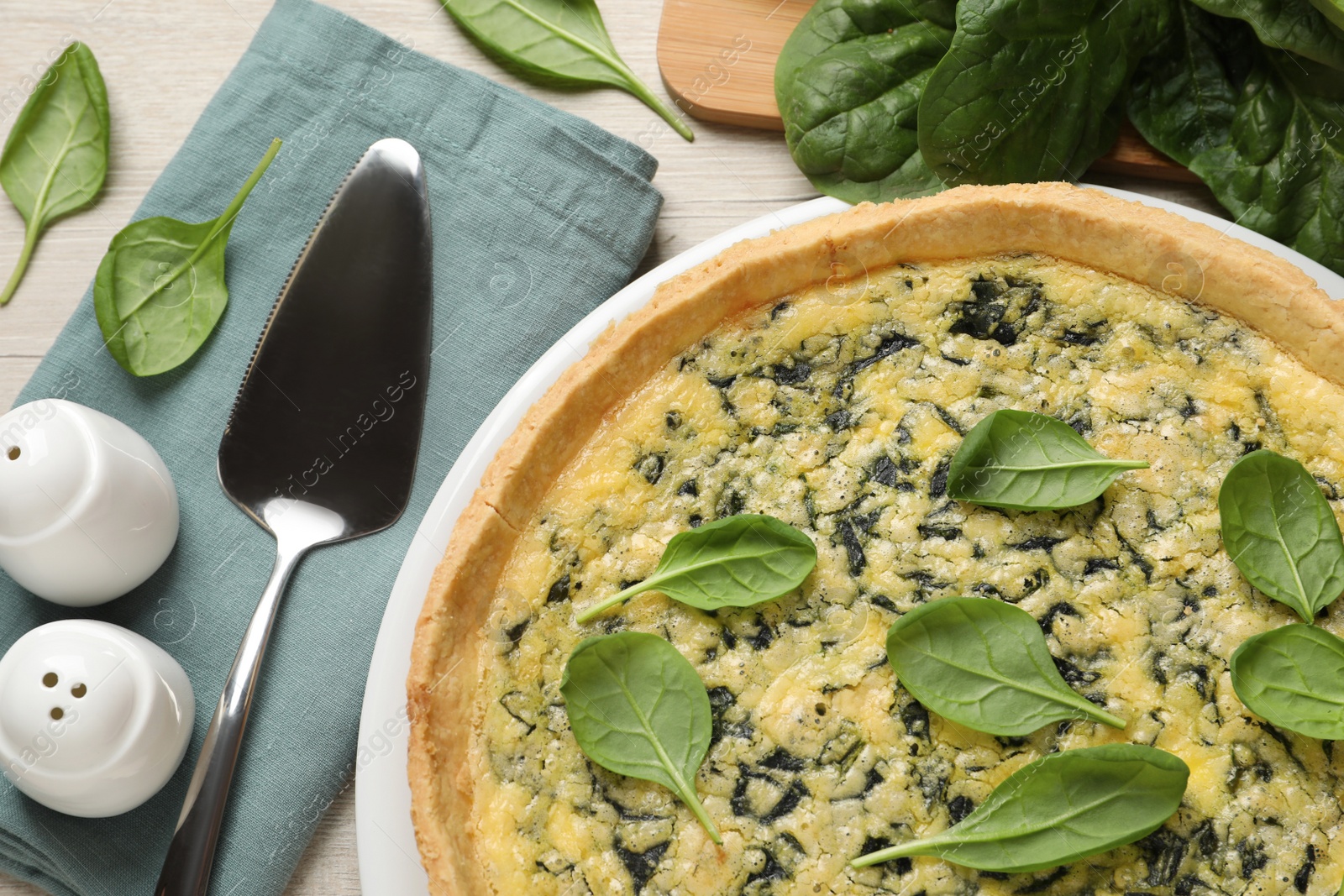 Photo of Delicious homemade spinach pie served on white wooden table, flat lay