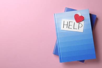 Photo of Notebooks and card with word HELP on color background, top view. Space for text