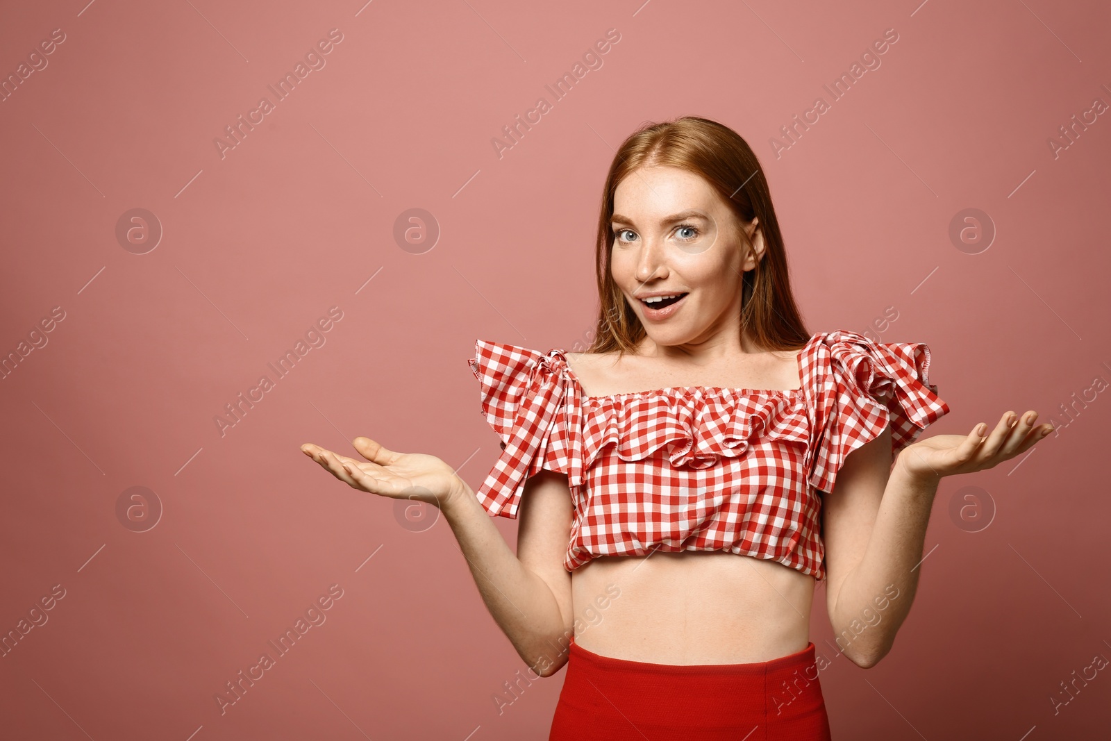 Photo of Portrait of surprised young woman on pink background, space for text