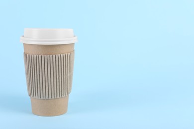 Photo of Paper cup with plastic lid on light blue background, space for text. Coffee to go