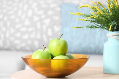 Bowl of fresh green apples on table indoors. Space for text