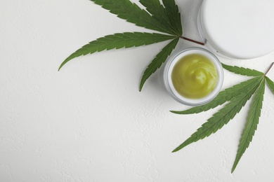 Photo of Jars of hemp cream on white table, flat lay with space for text. Organic cosmetics