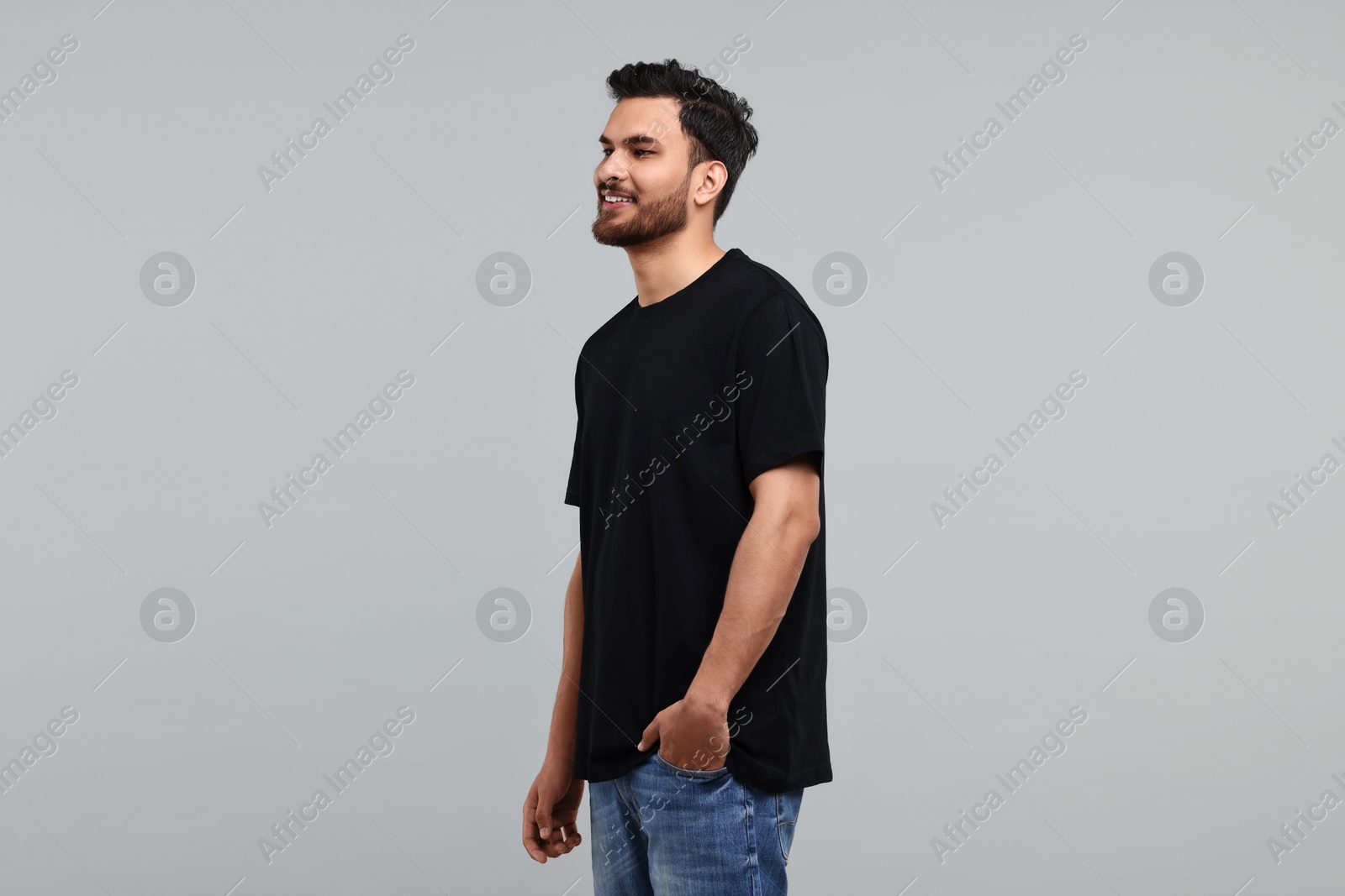 Photo of Smiling man in black t-shirt on grey background