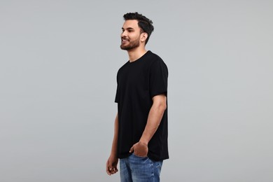 Smiling man in black t-shirt on grey background
