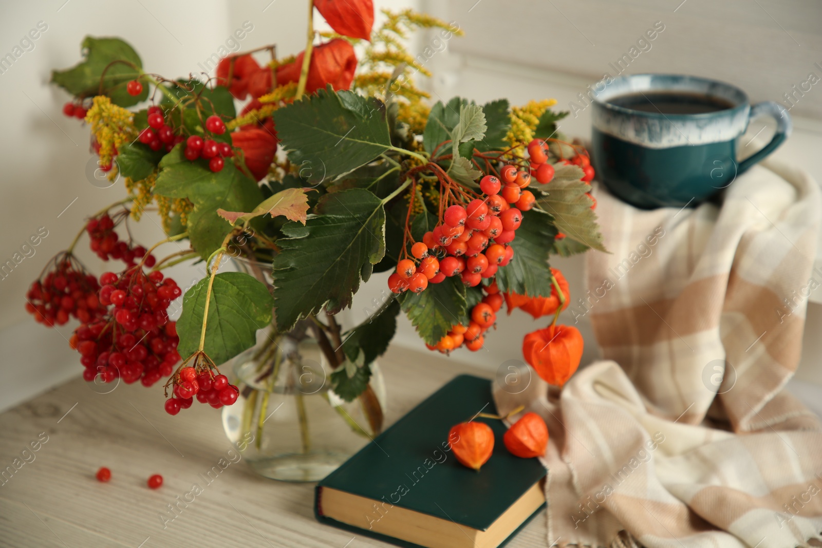 Photo of Beautiful autumn composition with cup of drink and book indoors