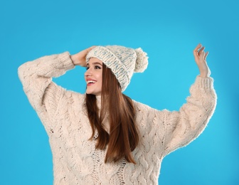 Young woman wearing Christmas sweater on blue background