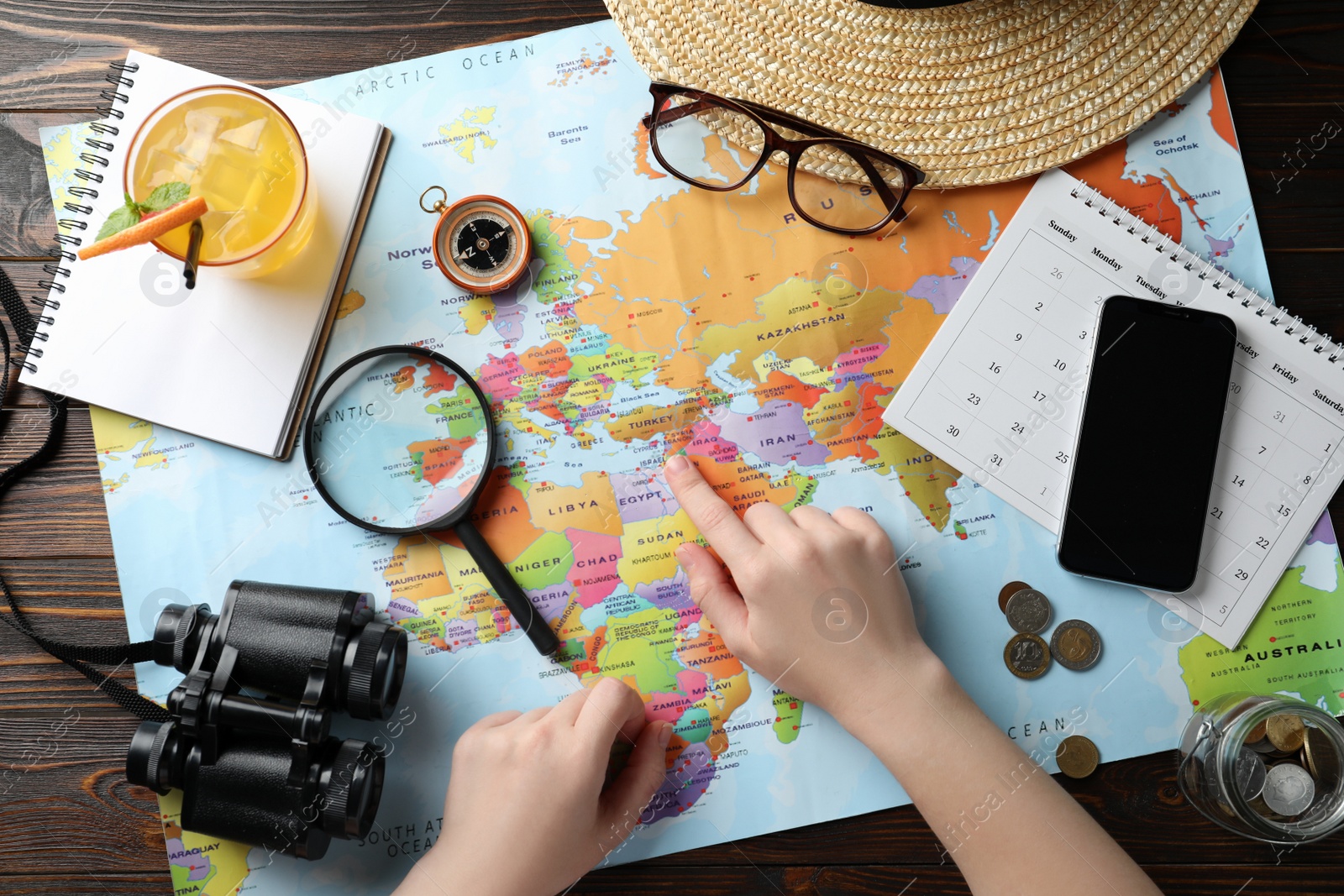 Photo of Woman with world map and accessories at table, top view. Travel during summer vacation